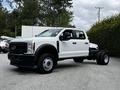 A 2024 Ford F-550 truck in white with a chassis cab design and visible front grille parked on a gray surface