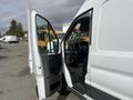 A 2023 Ford Transit with an open driver's side door showcasing the interior with steering wheel and dashboard visible