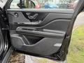 The interior door panel of a 2020 Lincoln Corsair featuring black leather upholstery and chrome accents with controls for windows and door locks