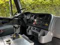 Interior view of a 2010 Freightliner M2 106 showing the dashboard controls gear shifter and various buttons and knobs for operation
