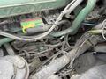 Close-up view of the engine components of a 2012 Volvo VNL featuring various cables and connectors visible among the machinery