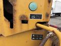 A yellow Vermeer Corporation BC1200XL with a visible control panel featuring buttons and labels illustrating operational functions and safety instructions