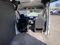 Interior view of a 2022 Ford Transit showing two front seats a dashboard and an empty cargo area behind