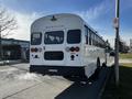 2022 Blue Bird Vision school bus with a white exterior and multiple rear lights parked on the side of a street