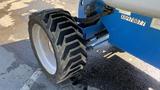 A close-up view of the large, rugged tire of a 2008 Genie S-65 Boom Lift showcasing its distinctive tread pattern and robust build