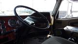 The interior of a 2003 International 5600i truck featuring a large steering wheel dashboard with gauges and a driver seat