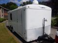 A white 2004 Royal 18 foot office trailer with a diamond plate skirt and a hitch at the rear