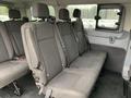 Interior seating of a 2017 Ford Transit with three rows of gray fabric seats featuring vertical stripes and headrests