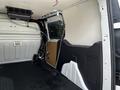 Interior of a 2016 Ford Transit Connect showing a spacious cargo area with a partition and storage solutions attached to the ceiling