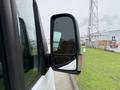 A side mirror of a 2019 Mercedes-Benz Sprinter with rain droplets on its surface