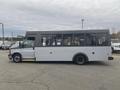 A 2017 Chevrolet Express bus in profile view with large windows and a gray exterior