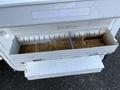 A white drawer from a 2008 Ford Econoline with a dirty interior and a divider in the center