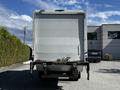 A white 2021 Hino 338 box truck viewed from the rear with a plain back door and a visible hitch and trailer connection