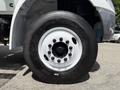 Close-up of a 2022 International MV607 truck tire featuring a black rubber tread and a white alloy wheel with a central hub and multiple lug nuts