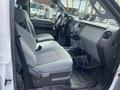 Interior of a 2015 Ford F-550 showing two gray cloth seats and a dashboard with various controls and a gear shift