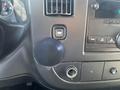The dashboard panel of a 2013 Chevrolet Express featuring a circular knob an air vent a button and audio controls