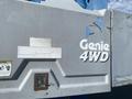 A close-up of the side of a 1997 Genie S-65 4X4 with the logo visible and some wear on the surface including scratches and a faded label