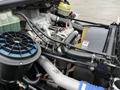 Engine compartment of a 2005 Freightliner M2 106 showing various engine components including hoses a radiator and an air filter