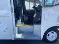 A 2012 Ford Econoline with an open side door showing the interior including seats and a step leading inside