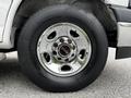 Close-up of a shiny chrome wheel from a 2023 GMC Savana featuring multiple spokes and a black rubber tire