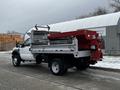 A 2008 Ford F-450 SD with a red dump body and silver trim parked on a street