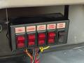 Control panel with five red switches labeled TCL Beacon Left Alley Right Alley and Bin HTR