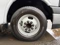 A close-up view of a 2019 Chevrolet Express tire and wheel featuring a black tire with a white rim and bolts