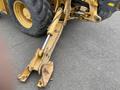 A close-up of the hydraulic arm and bucket attachment of a 2012 John Deere 310SJ construction vehicle