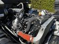 Close-up of the engine compartment of a 2021 Hino 338 showing various components like hoses turbocharger and radiator