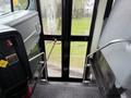 Interior view of a 2016 International CE300 bus showing the staircase and entrance area with handrails and a clear view through the door