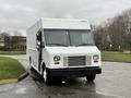2018 Ford E-450 delivery truck with a white exterior and large front windows positioned at an angle on a paved surface