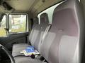 Interior of a 2014 International Durastar showing three gray fabric seats with slight wear and a few papers resting on the center seat