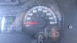 Speedometer and fuel gauge of a 2011 Ford Econoline displaying a speed of 0 km/h and a low fuel warning