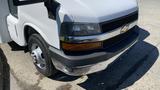 A 2011 Chevrolet Express van with a white exterior and chrome accents on the front grille and bumper