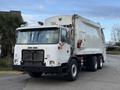 A 2010 Autocar Xpeditor garbage truck with a white exterior featuring a front-mounted cab and a rear compaction system
