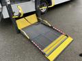 A yellow and gray loading ramp with a metal mesh surface intended for loading or unloading items on a vehicle