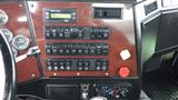 The interior dashboard of a 2019 Western Star Trucks 4900 featuring various switches and controls displayed on a wood panel with gauges and a radio system