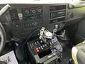 Interior view of a 2013 Chevrolet Express featuring a dashboard with controls and a radio along with a console equipped with buttons and a mobile device holder
