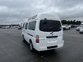 A white 2002 Nissan Van with a high roof design and a rear window visible