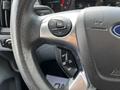 Close-up of a steering wheel from a 2018 Ford Transit featuring control buttons for navigation and audio settings