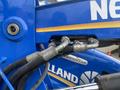 Close-up of hydraulic hoses and fittings on a blue 2016 New Holland T475 tractor