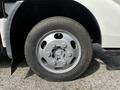 A close-up view of a silver wheel with a circular design mounted on a 2004 Toyota Toyoace tire