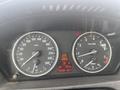 Dashboard of a 2009 BMW X5 showing speedometer and tachometer with digital readout of distance and fuel consumption
