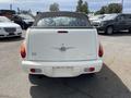 A white 2005 Chrysler PT Cruiser convertible viewed from the rear with a black soft top and distinctive taillights