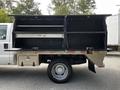 A 2016 Ford F-550 with an open utility bed featuring multiple storage compartments and shelves suitable for tools and equipment