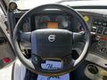 Steering wheel of a 2005 Volvo VND 122 with controls and a dashboard displaying gauges and screens