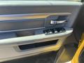 The interior door panel of a 2015 RAM 1500 featuring control buttons for power windows and door locks in a gray and black color scheme