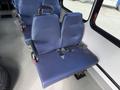 A blue bench seat from a 2020 Chevrolet Express with seatbelts visible and a metal mounting plate attached on the floor