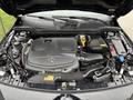 Engine compartment of a 2016 Mercedes-Benz GLA-250 featuring a prominent black engine cover with the Mercedes-Benz logo and various components like the air intake and fluid reservoirs