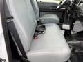 A gray vinyl bench seat in a 2017 Ford F-750 with seatbelts and a simple interior layout featuring controls and a floor mat.